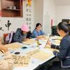 Students gathered around a table for Chinese calligraphy
