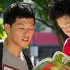 two male students reading a book