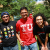 Five Temple students in black and red Temple T-shirts smiling at the camera