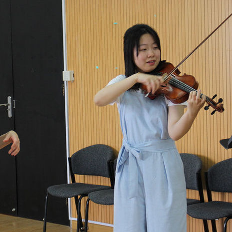 A Boyer professor instructing a student in violin