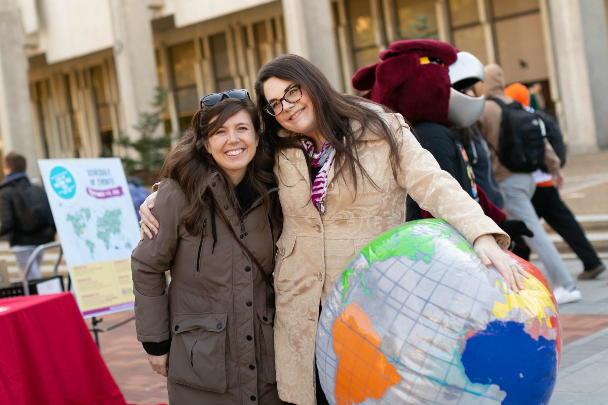 Two smiling women holding a blow-up globe.
