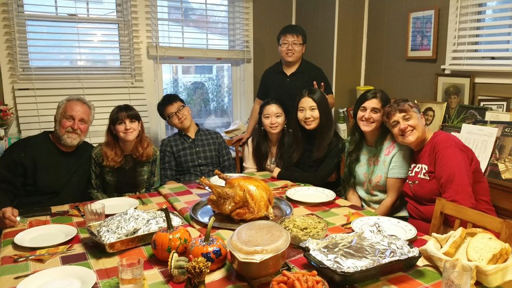 Family and students posing at the dinner table